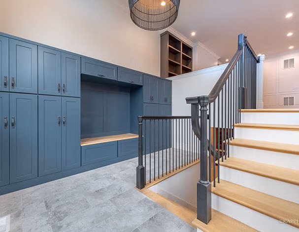 Blue mudroom with staircase and built-in storage