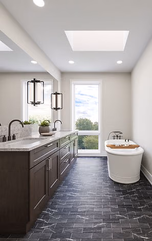 Long bathroom with dark floor and freestanding tub